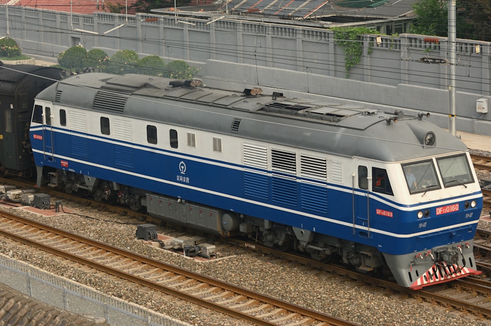 a blue and white train traveling down train tracks