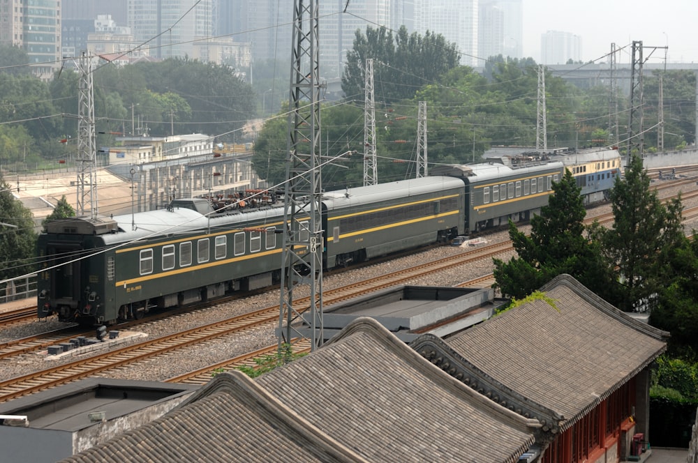 a train traveling down tracks next to a tall building