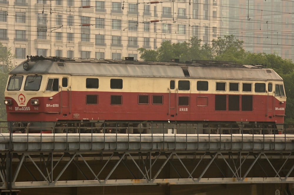 a red and white train traveling over a bridge