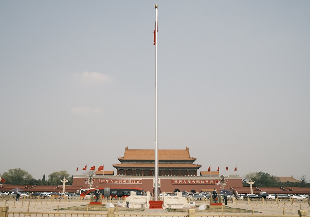 a tall flag pole in front of a building
