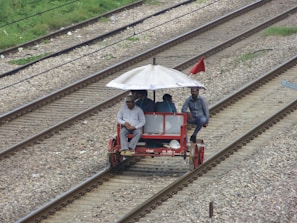 A lively group of friends laughing together while pedaling through a sunny Charlotte street on the red and blue pedal trolley