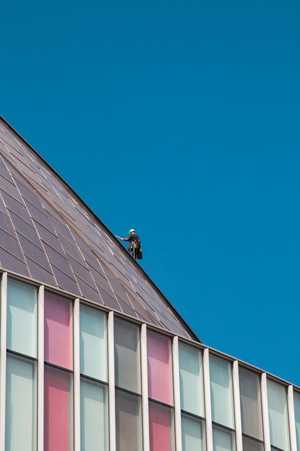 a man on a roof working on the roof of a building