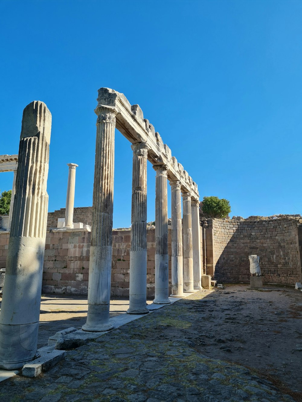 a row of stone pillars in front of a blue sky