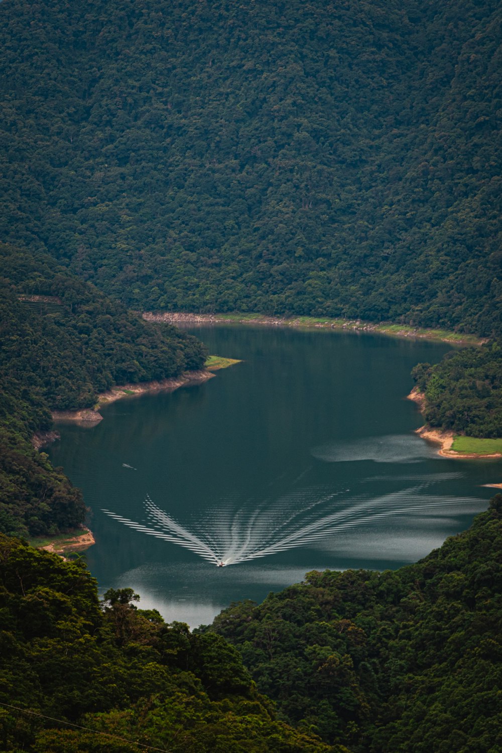 a large body of water surrounded by lush green hills