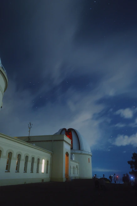 A summer intensive workshop with students gathered around a telescope under a clear sky