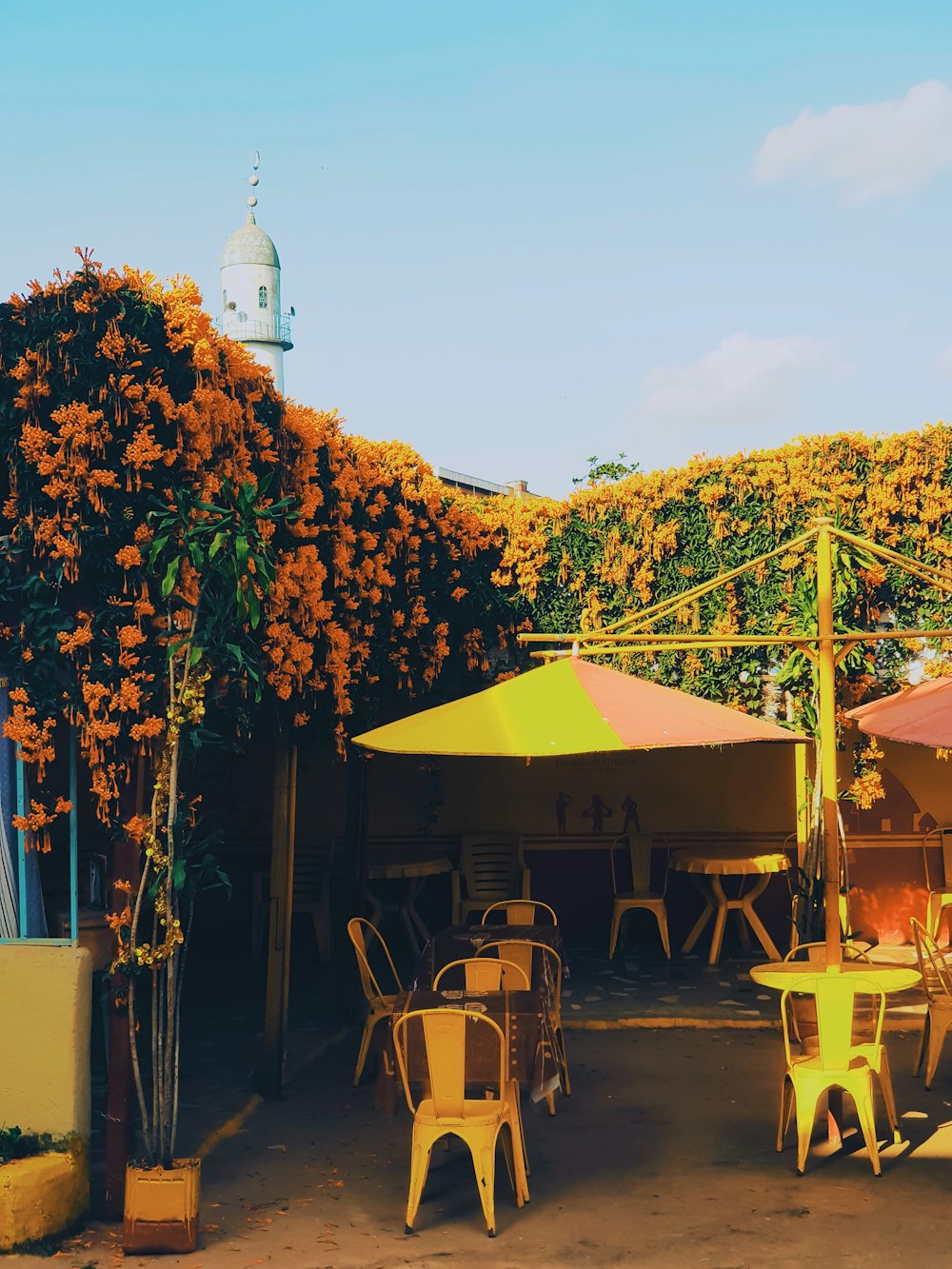 a group of tables and chairs under umbrellas