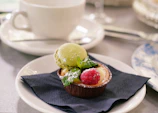 A vibrant dessert plate with a slice of fruit tart garnished with mint leaves.