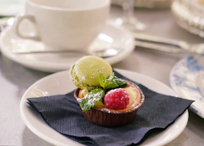A vibrant dessert plate with a slice of fruit tart garnished with mint leaves.