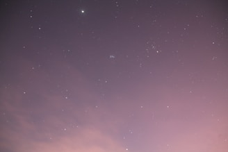 An original illustration showing a starry night sky with soft pink and violet hues, evoking calm and hope.