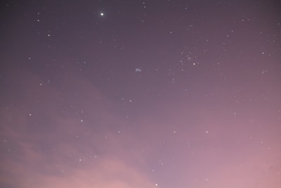 A delicate watercolor painting of stars scattered across a purple and blue gradient sky.