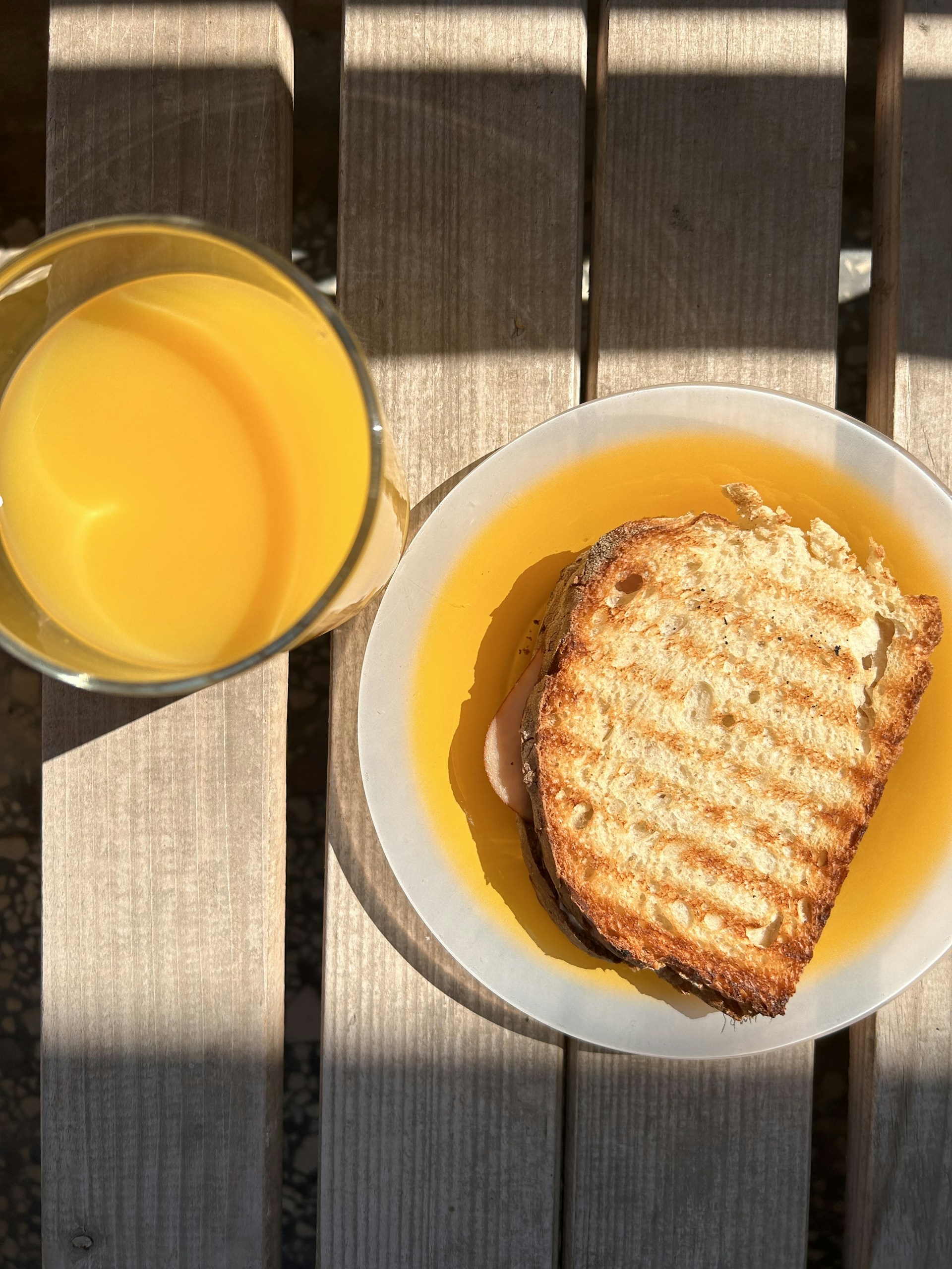 A cozy corner of a favorite local restaurant bathed in soft natural light, with a vibrant plate of fresh greens and a glass of orange juice on the table.