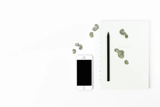 A stylish, clean table setup with a premium smartphone and minimal accessories on a white background.