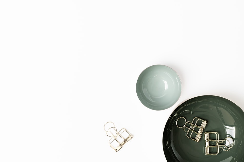 a pair of earrings sitting on top of a green bowl