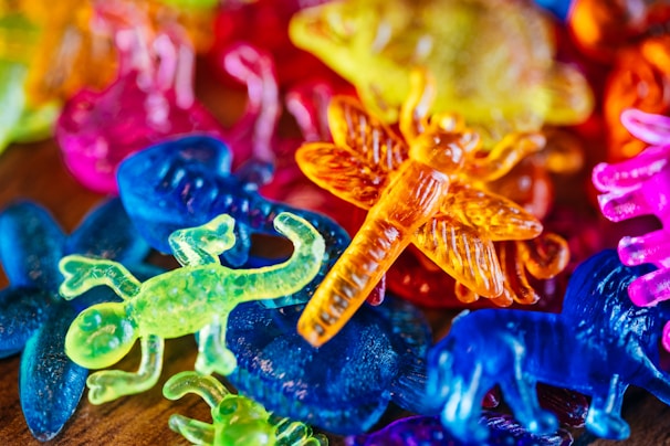 Close-up of colorful fantasy toys with smooth textures and playful designs on a velvet cloth.