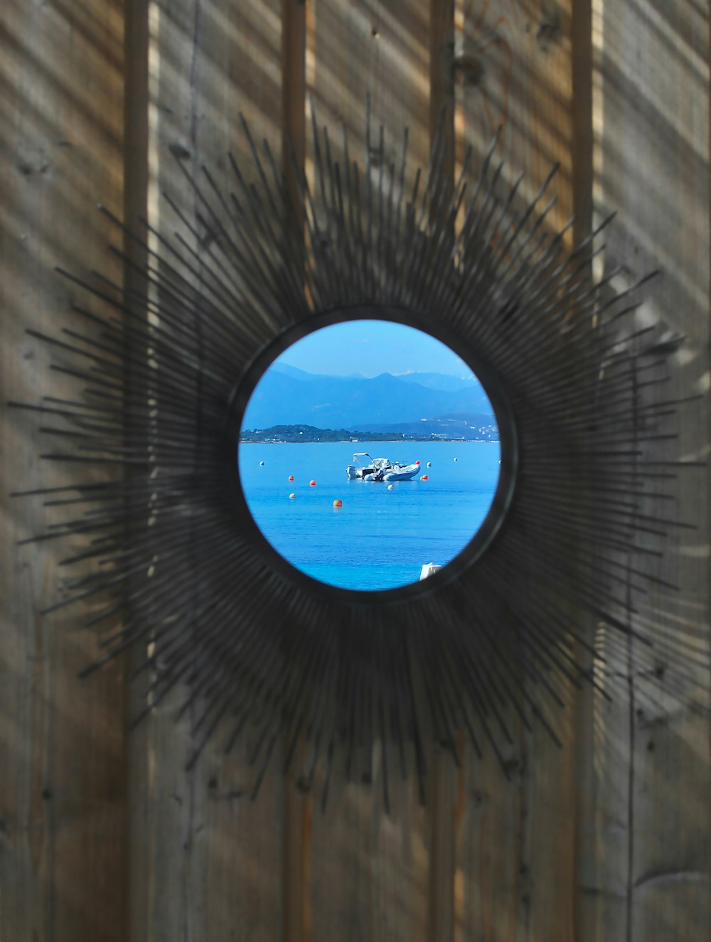 a view of a body of water through a circular mirror