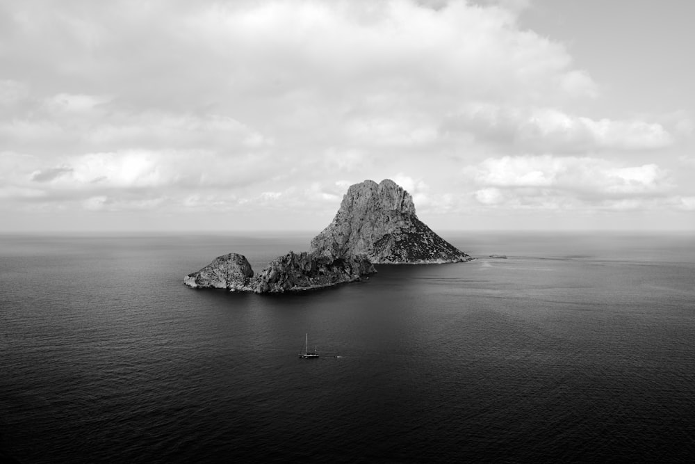 a black and white photo of an island in the middle of the ocean