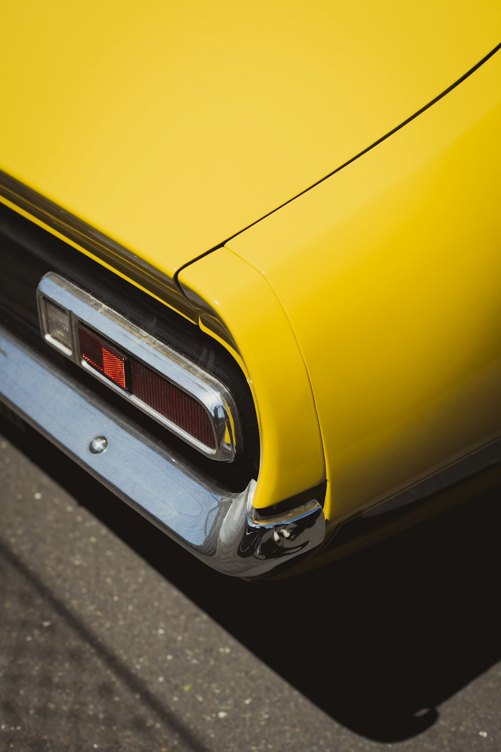 a close up of the tail end of a yellow car