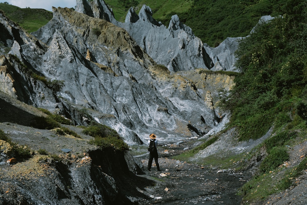 a person standing on a rocky path in the mountains