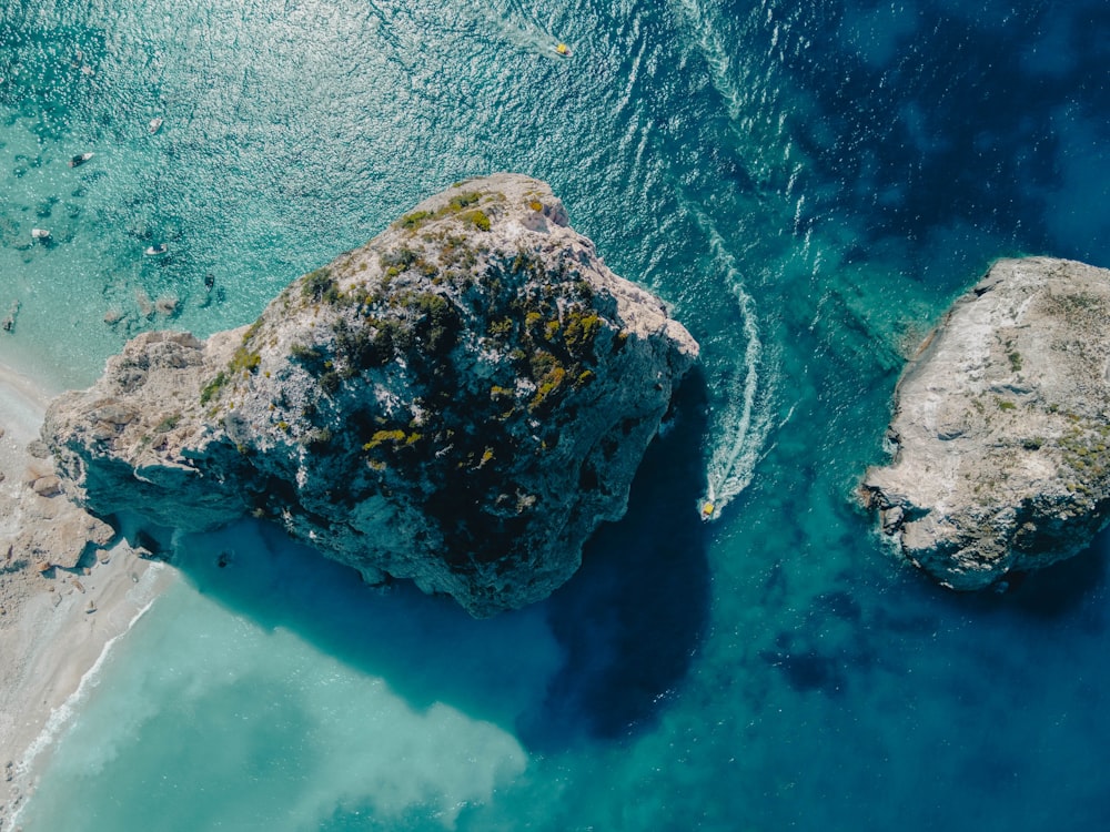 an aerial view of a rocky outcropping in the ocean