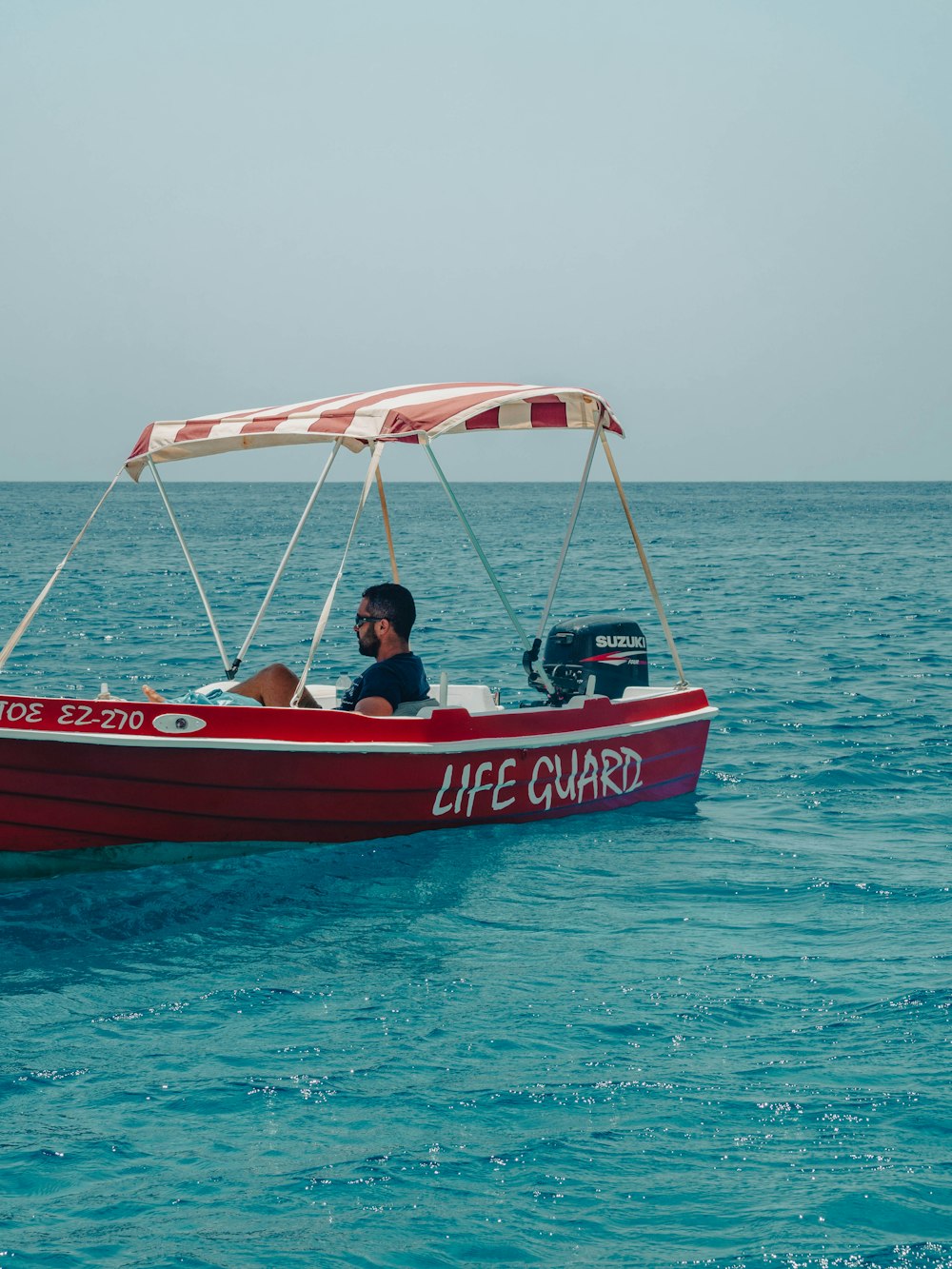 a man in a life guard boat in the ocean