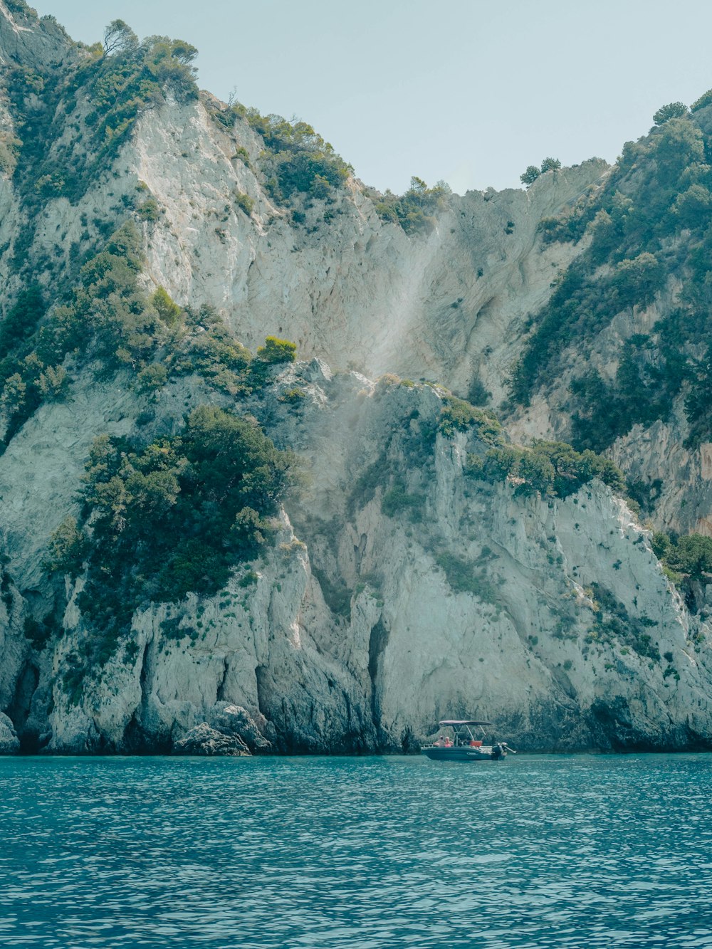a boat in a body of water near a mountain