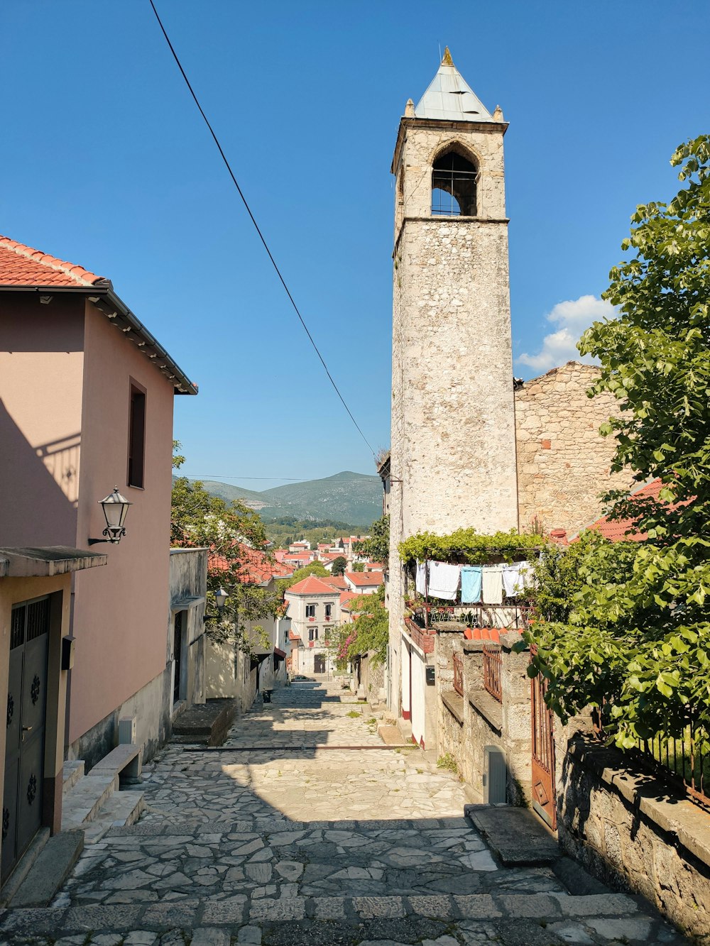 a cobblestone street with a clock tower in the background