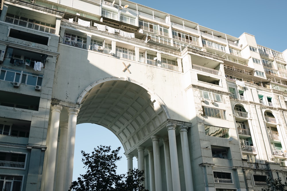 a tall white building with a clock on it's face