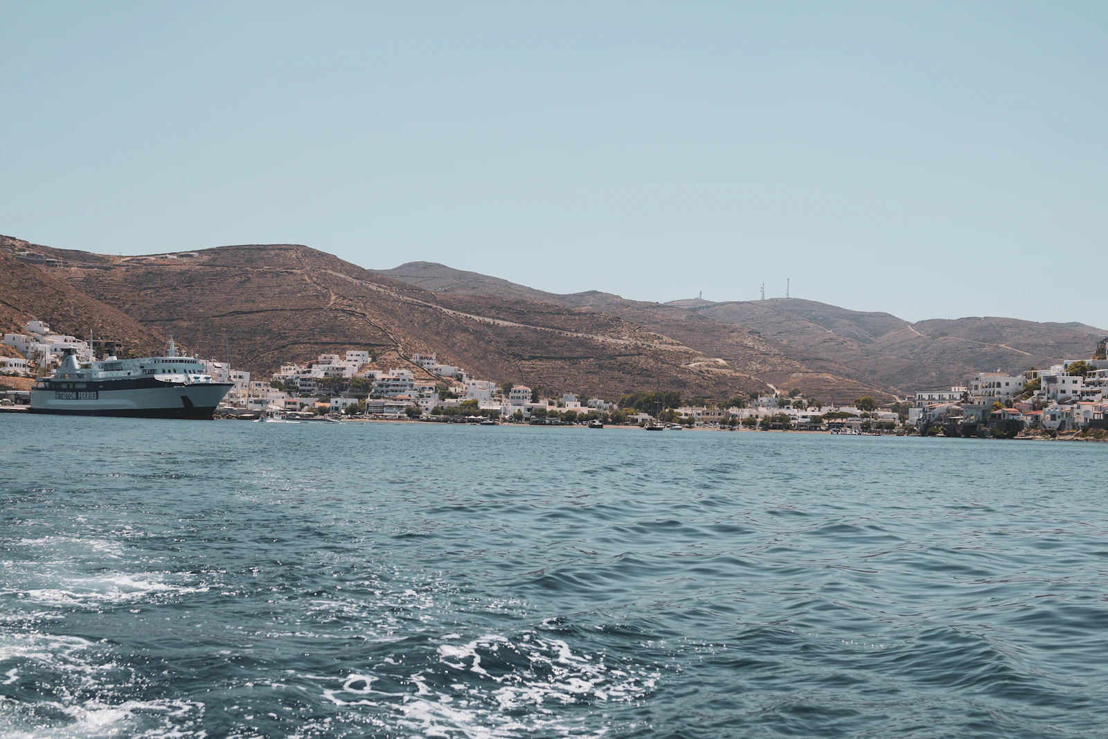 Een wit cruiseschip in een Griekse baai