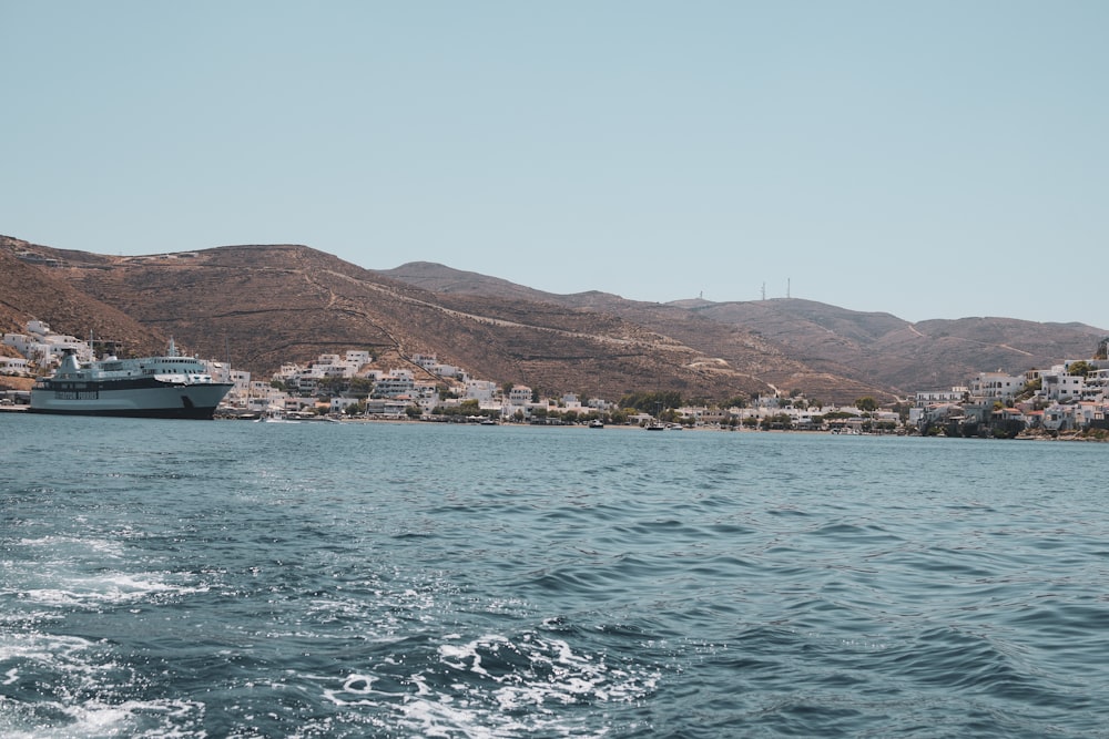 a cruise ship in the water with mountains in the background