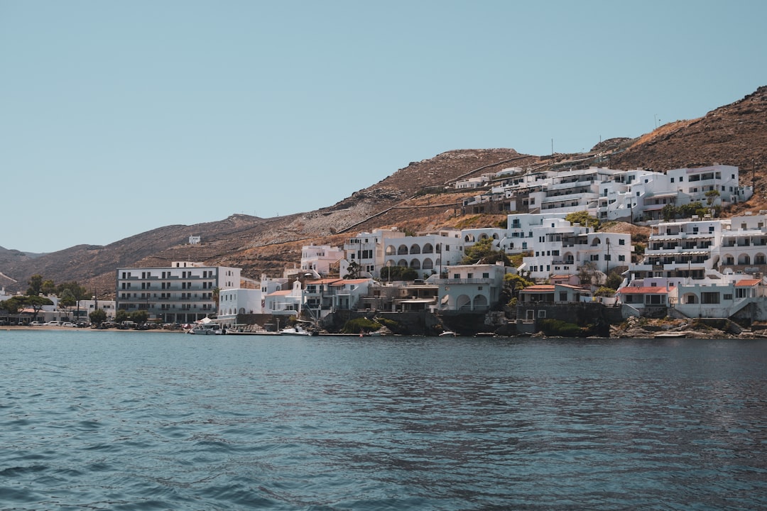 a body of water with houses on a hill in the background, Kythnos port and view of the Aegean Sea