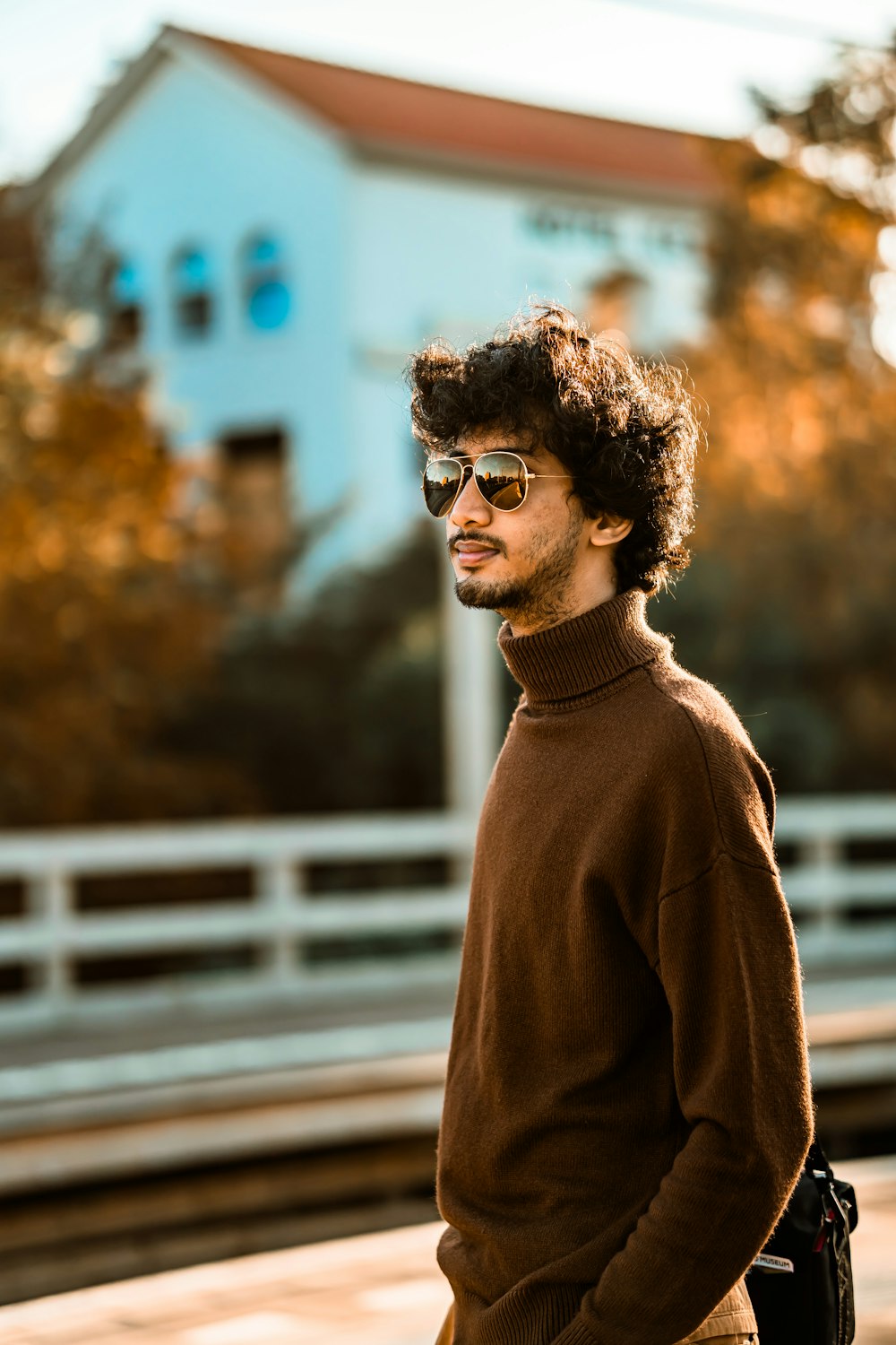 a man wearing a brown sweater and sunglasses