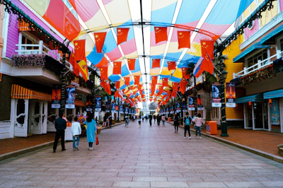A vibrant street scene in Ambato with locals engaging in daily activities under colorful banners.