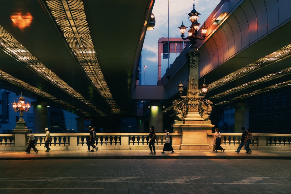 a group of people walking across a bridge