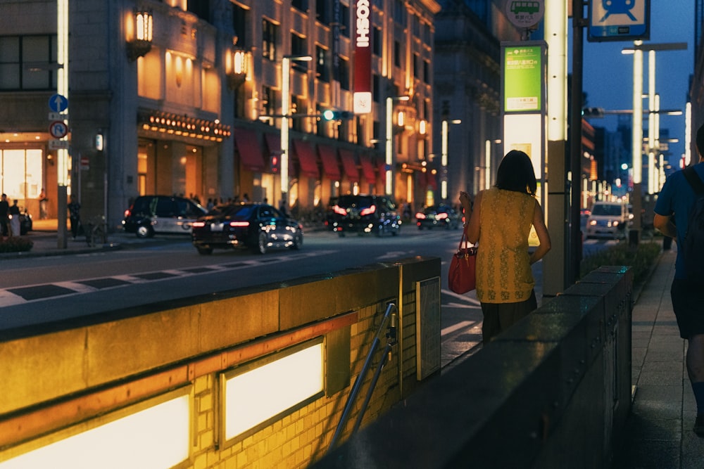 a woman walking down a street at night