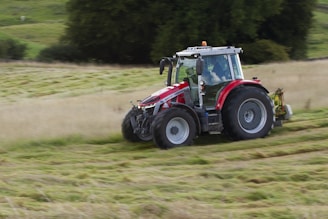 a tractor is driving through a field of grass