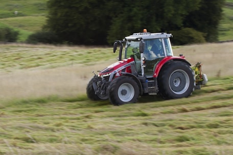 a tractor is driving through a field of grass
