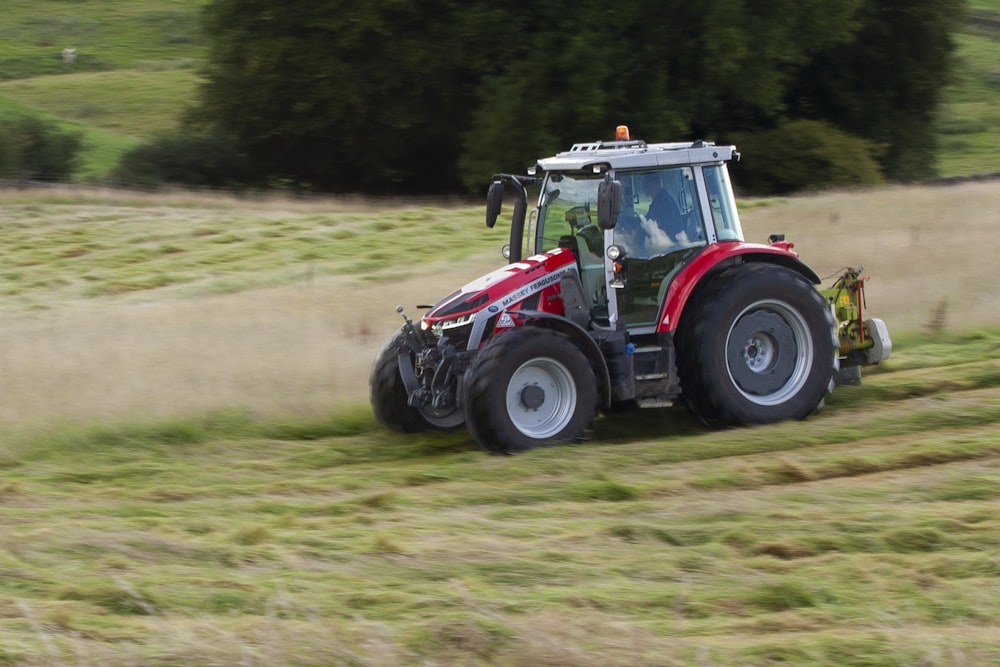 a tractor is driving through a field of grass