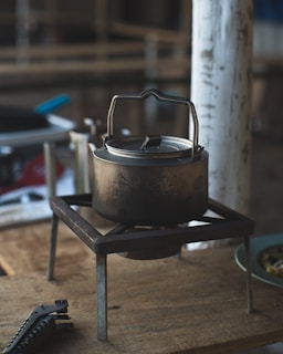 A sturdy aluminum cooker with a polished surface, placed on a rustic wooden countertop.