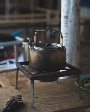 A sturdy aluminum cooker with a polished surface, placed on a rustic wooden countertop.