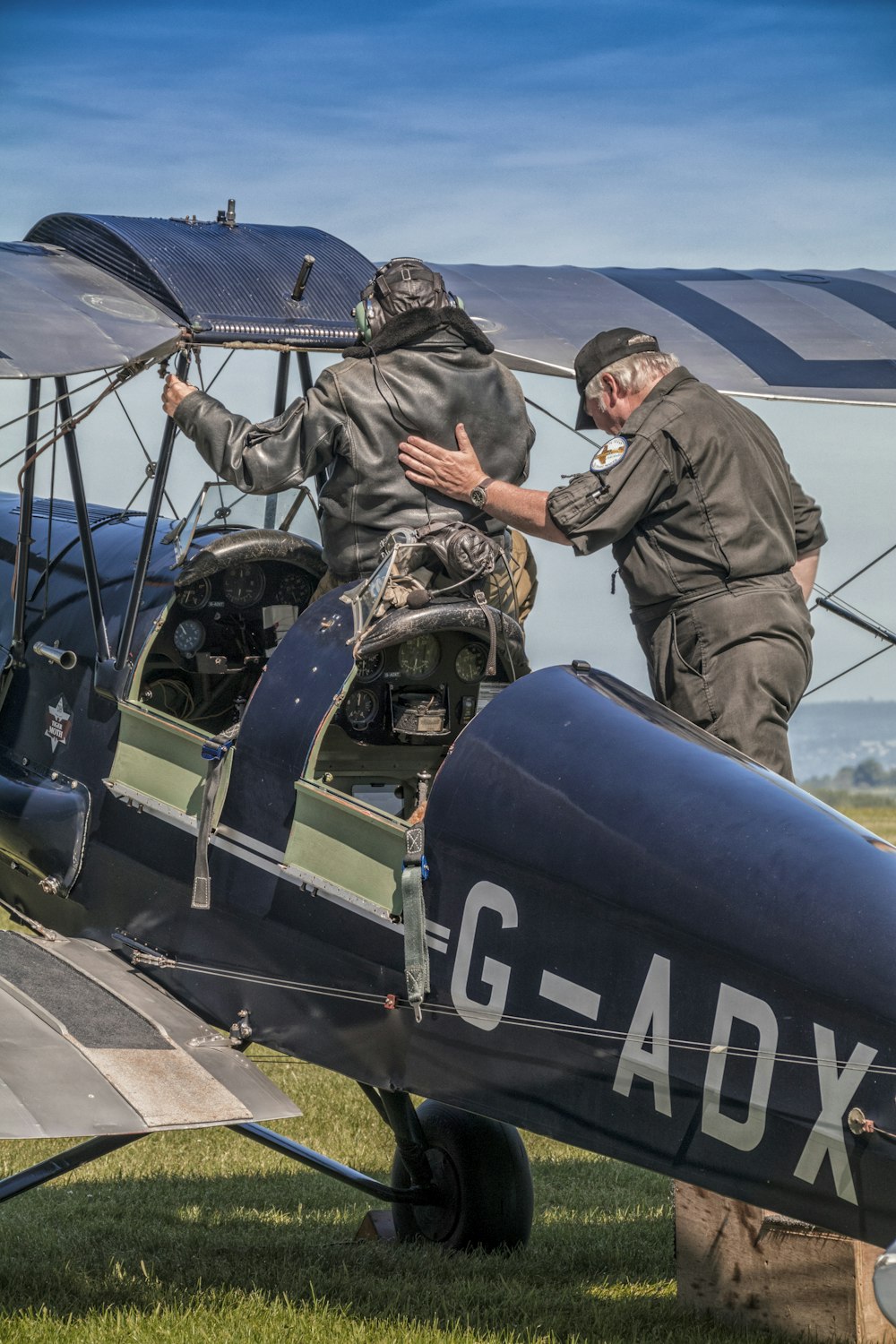 a couple of men standing on top of an airplane