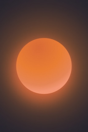 A glowing primordial sun casting warm light over a cosmic nebula.