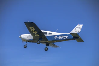 a small airplane flying through a blue sky