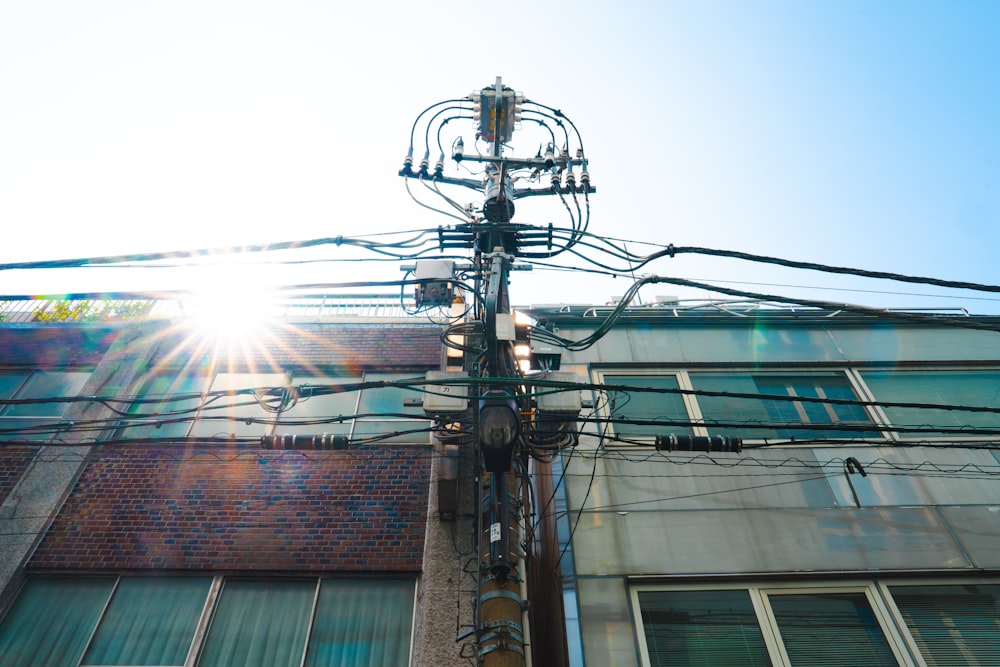 a pole with many wires and a building in the background