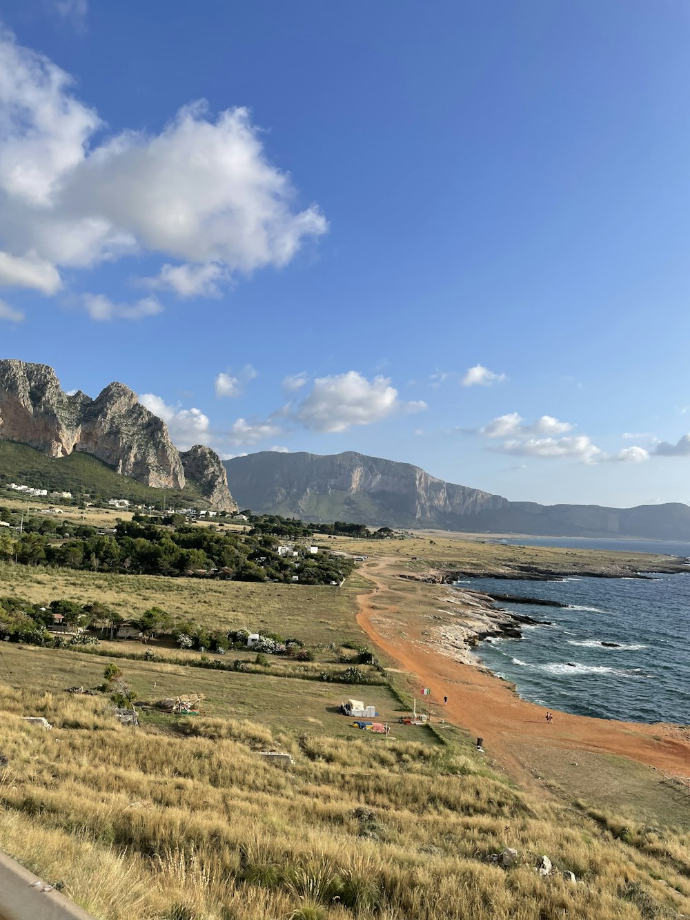 a scenic view of a beach with mountains in the background