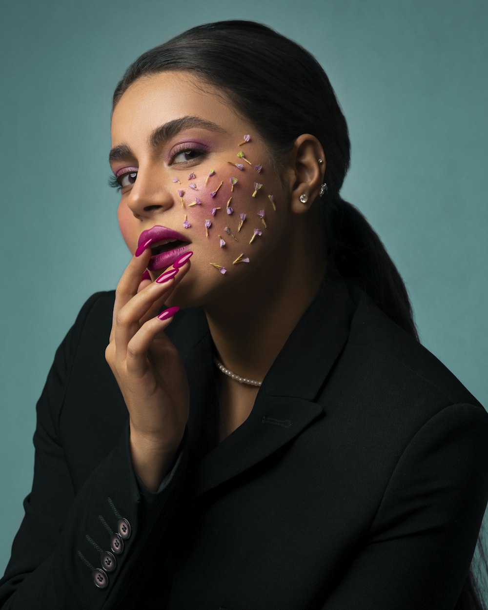 a woman in a black jacket with pink and gold sprinkles on her