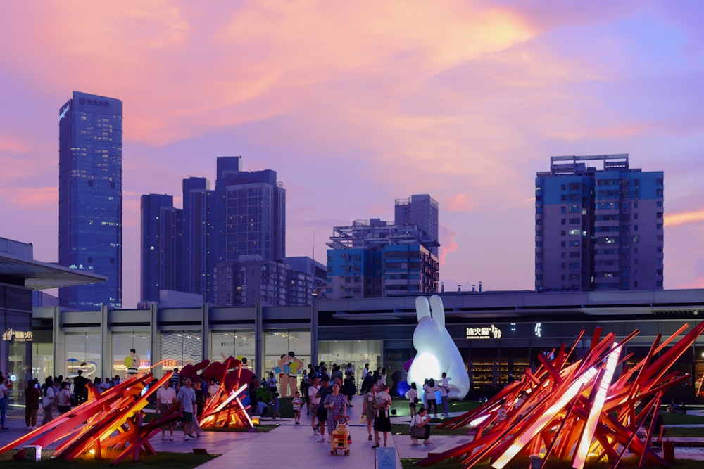 a group of people walking around a city at dusk