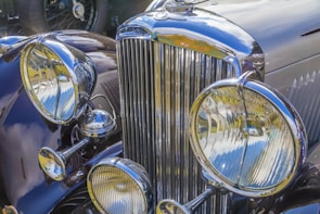 Close-up of a vintage car's polished chrome grill and headlights.