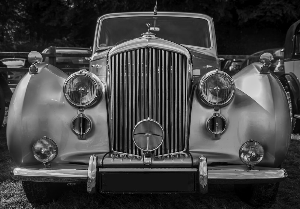 a classic car parked in a field of grass