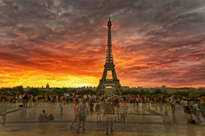 A vibrant photo of tourists enjoying the Eiffel Tower at sunset during a Europe tour