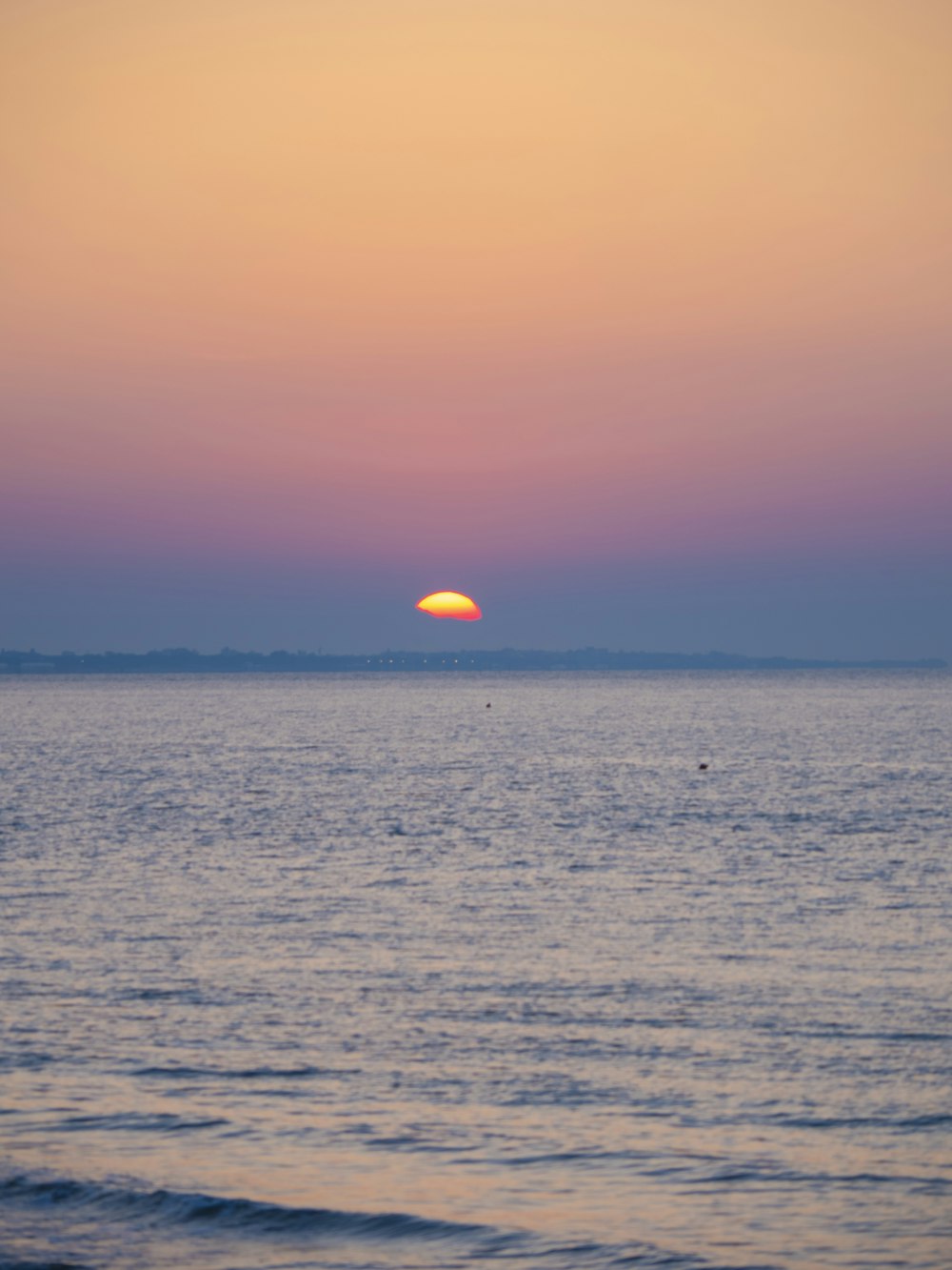 the sun is setting over the ocean on a clear day